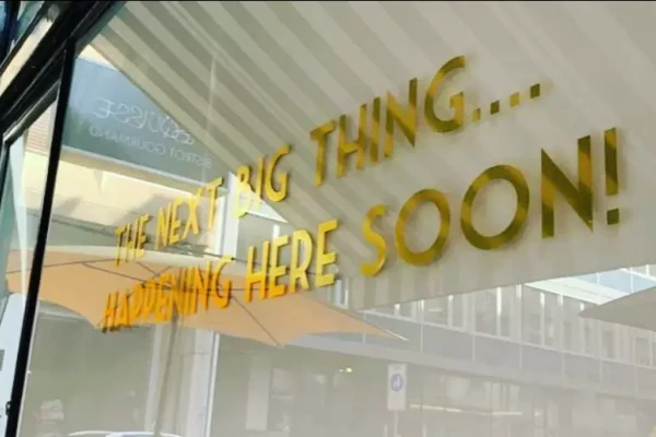 lettrage adhésif vinyle doré sur une devanture de magasin