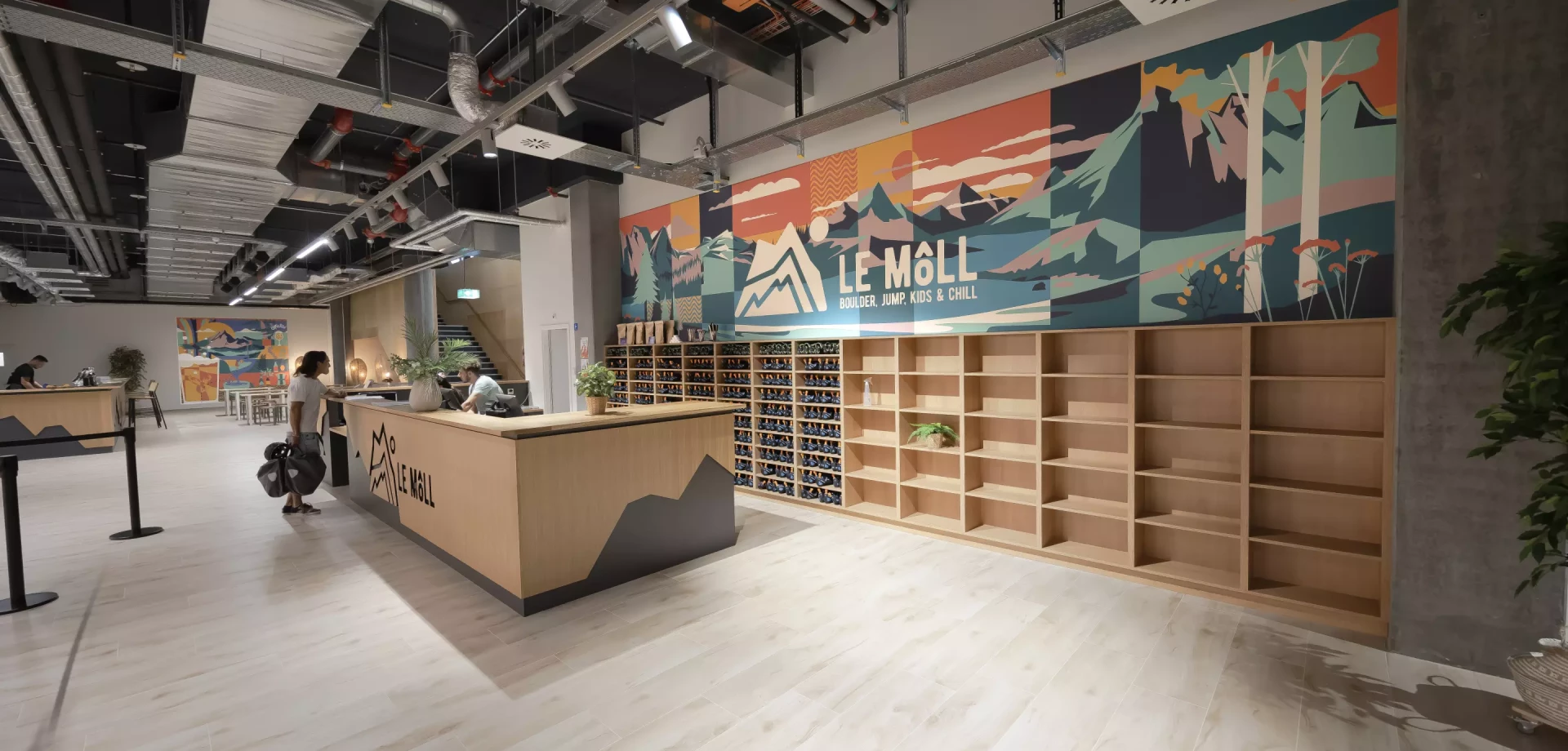 halle d'entrée d'une entreprise avec un graphisme au mur et des casiers à chaussure