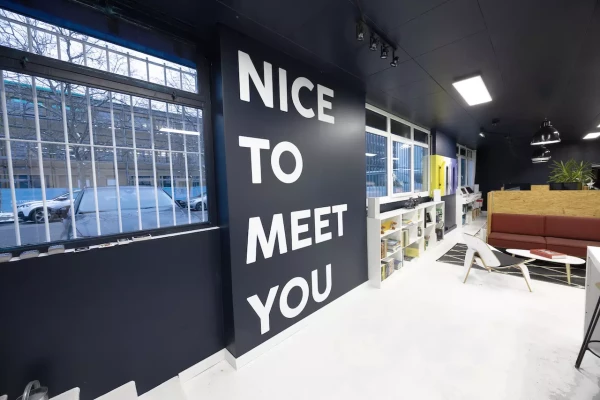 photo de l'intérieur d'un bureau avec un grand lettrages en vinyle blanc contre un mur