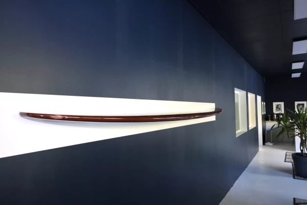 une planche de surf coupée en 2 contre un mur bleu