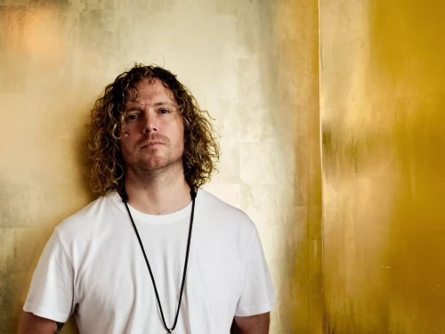 un homme devant un mur recouvert à la feuille d'or