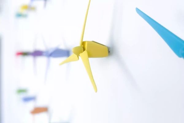 petites éoliennes de couleur contre un mur blanc