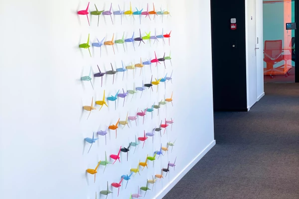 petites éoliennes de couleur contre un mur blanc