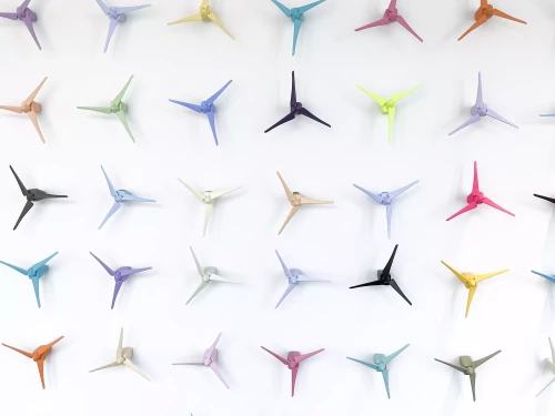 petites éoliennes de couleur contre un mur blanc