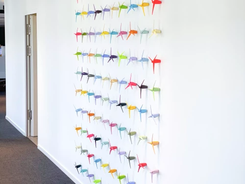 petites éoliennes de couleur contre un mur blanc