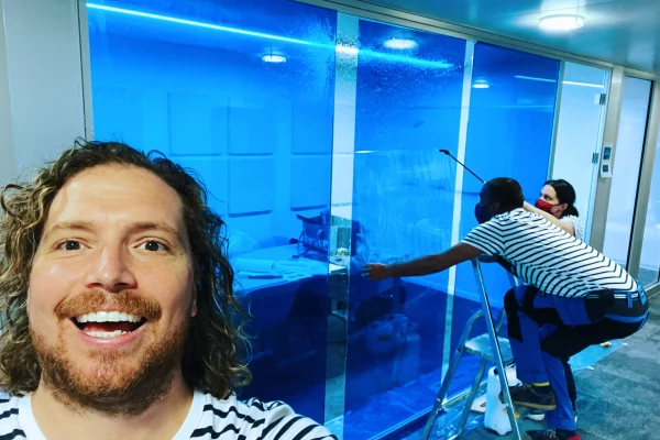 un bureau avec des vitre bleues et un homme qui sourit