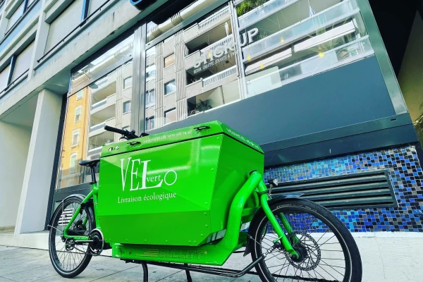 un vinyle adhésif publicitaire sur un vélo cargo vert