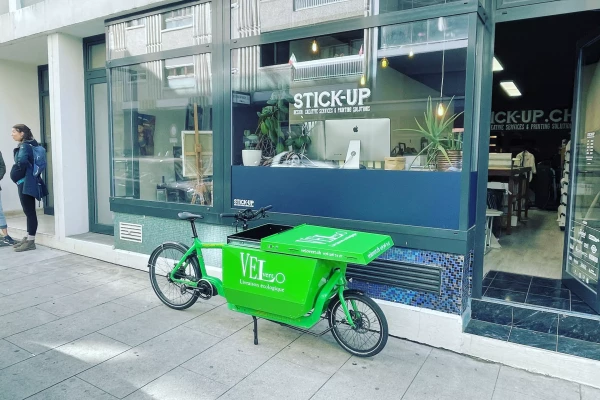 un vinyle adhésif publicitaire sur un vélo cargo vert