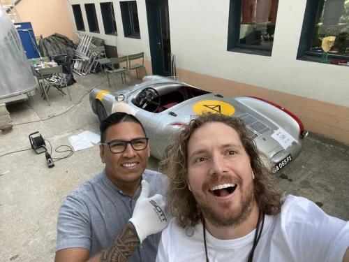 deux personnes qui rigolent devant une Porsche