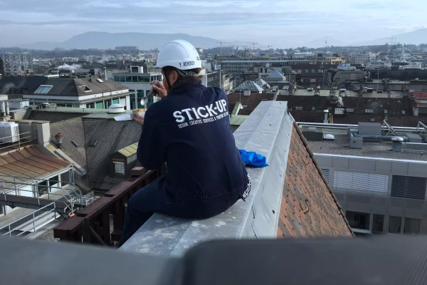 un ouvrier sur le toit d'un immeuble é Genève