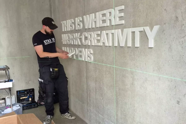 photo d'un homme qui travaille devant un mur de lettres 3d