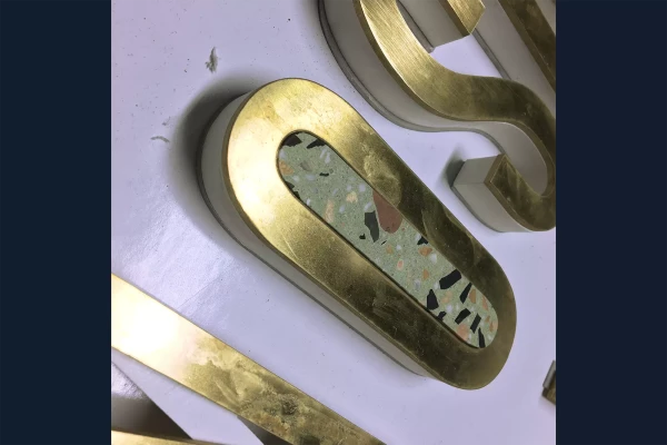 découpe de lettres en laiton et de terrazzo