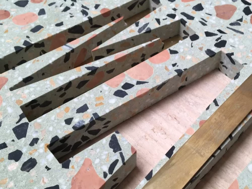 découpe de forme de lettres dans une plaque de terrazzo