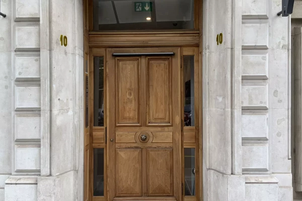 porte d'entrée d'un immeuble avec les numéros d'immeuble en laiton
